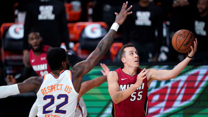 Miami Heat's Duncan Robinson goes to the basket as Phoenix Suns' Deandre Ayton defends